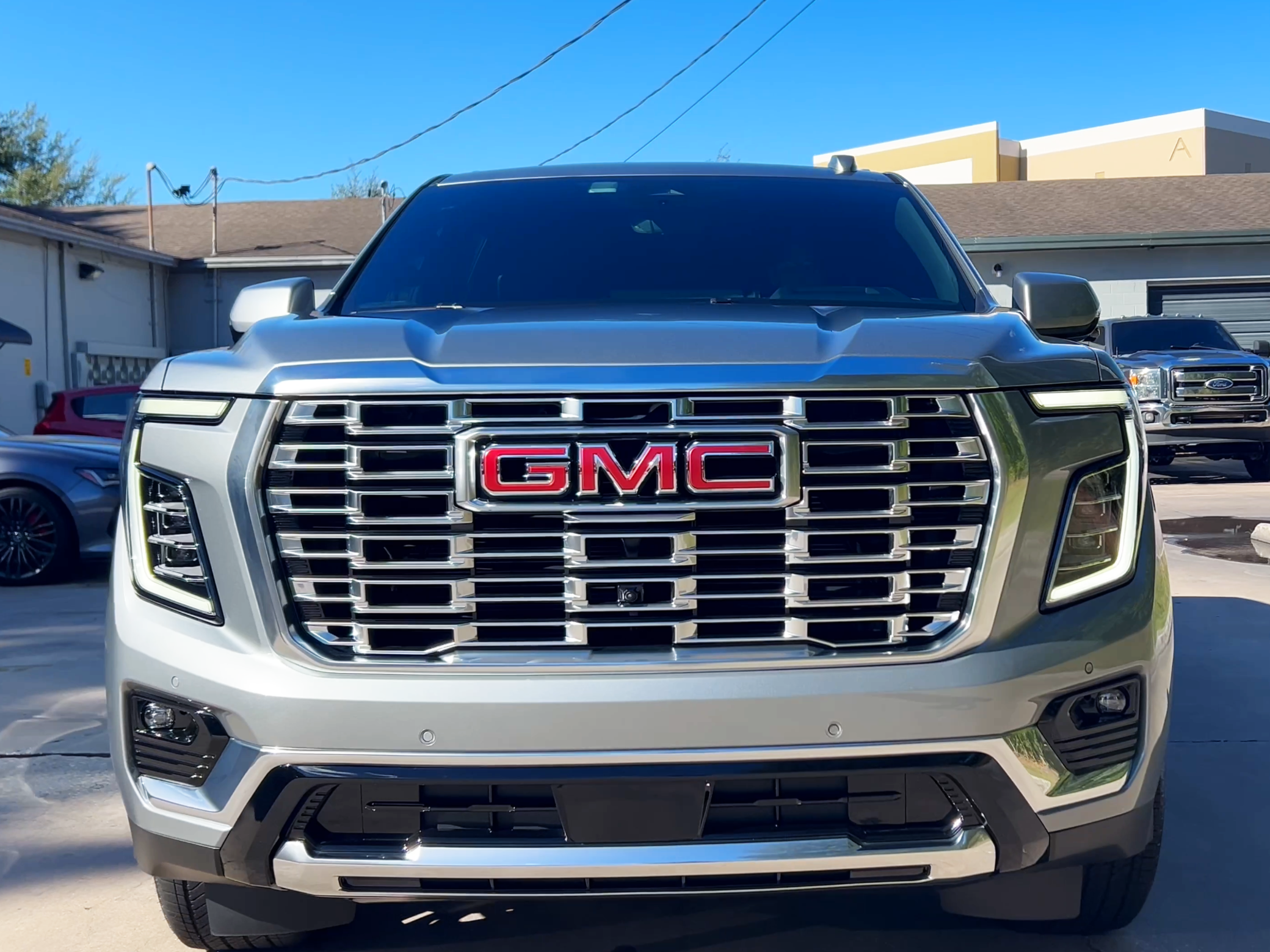 GMC truck front grille with clear sky background after mobile detailing in Tampa